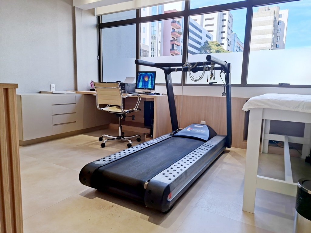 Sala do teste ergométrico: esteira diante da janela e a estação de monitoramento do cardiologista.